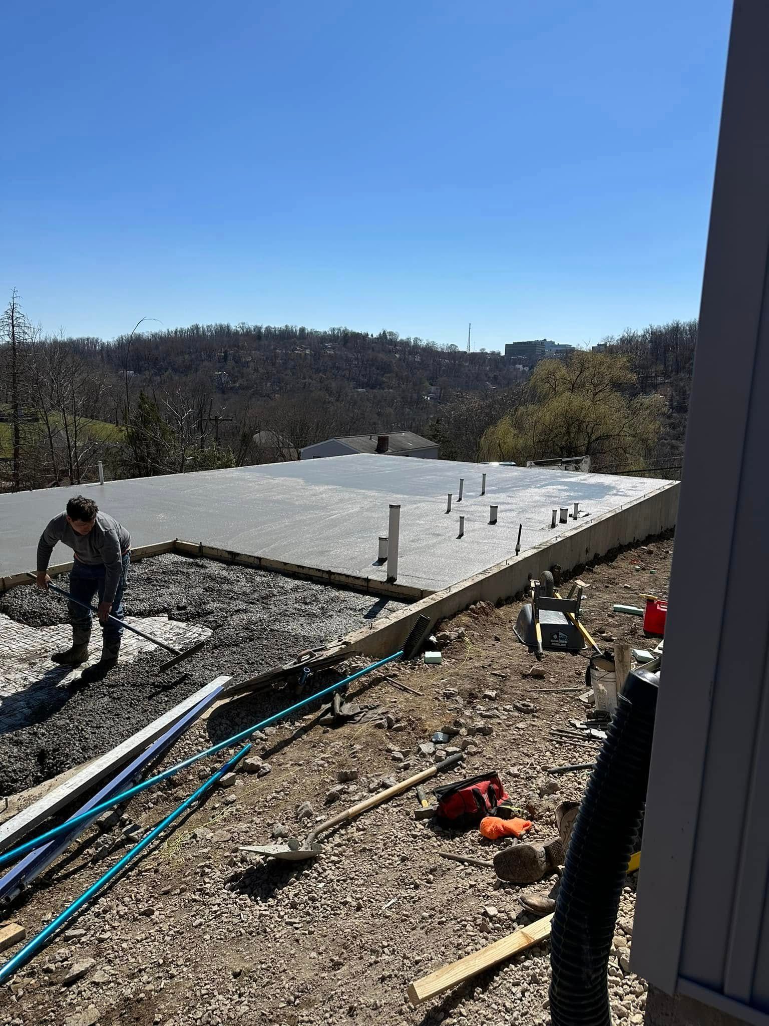 Workers installing a white roof on a hillside home on a sunny day.