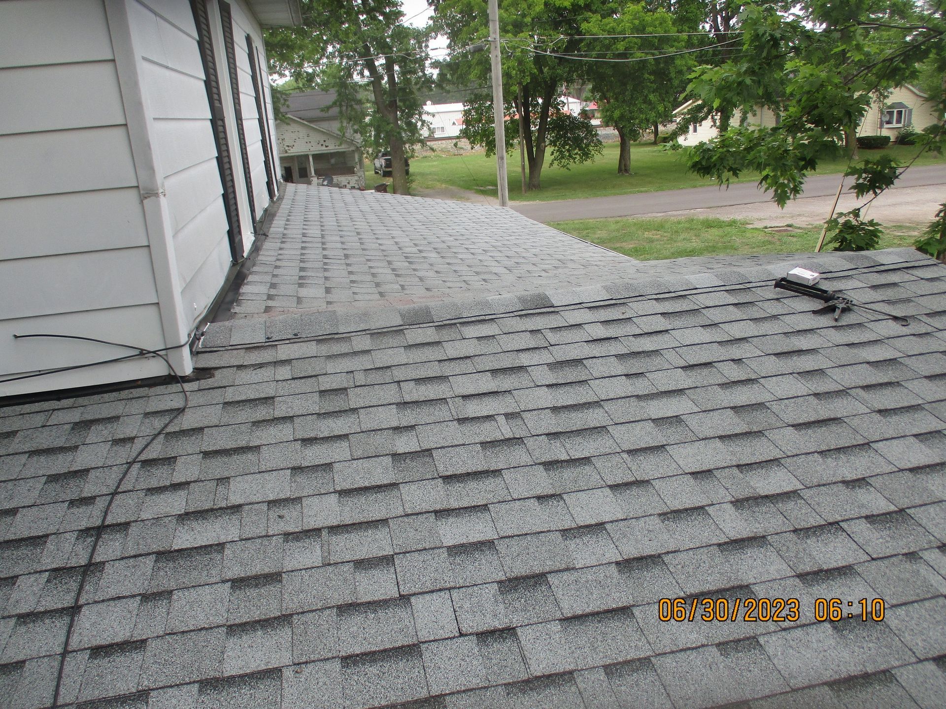 A roof with a lot of shingles is sitting on top of a house.