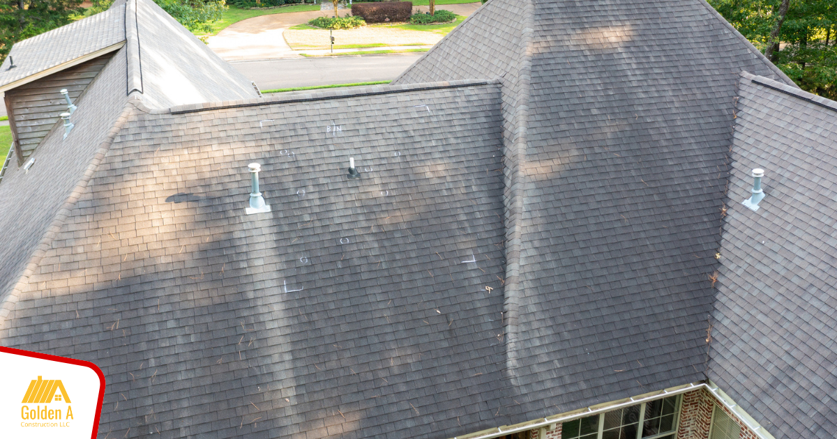An aerial view of a large house with a black roof.