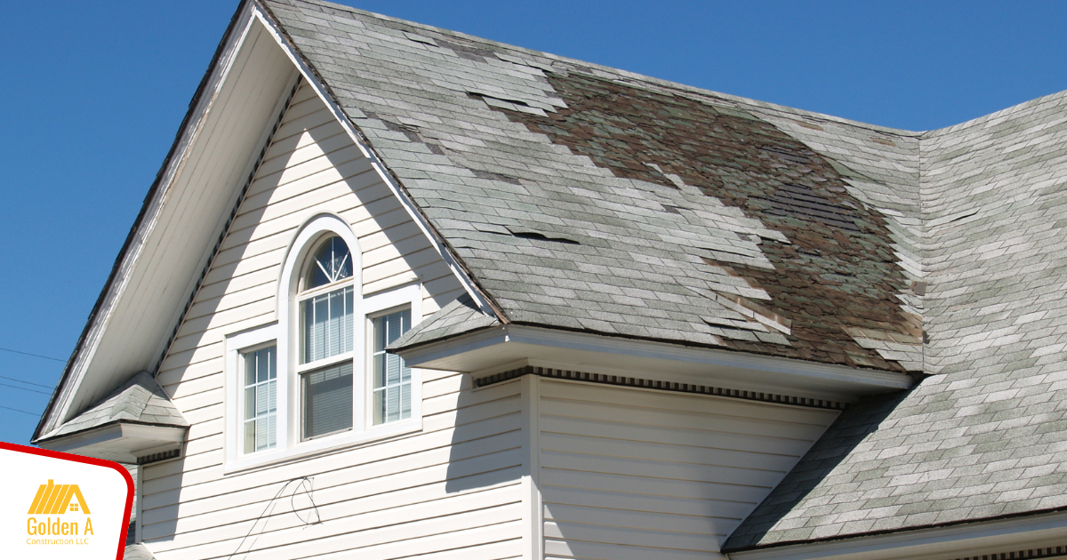 A white house with a roof that is covered in moss