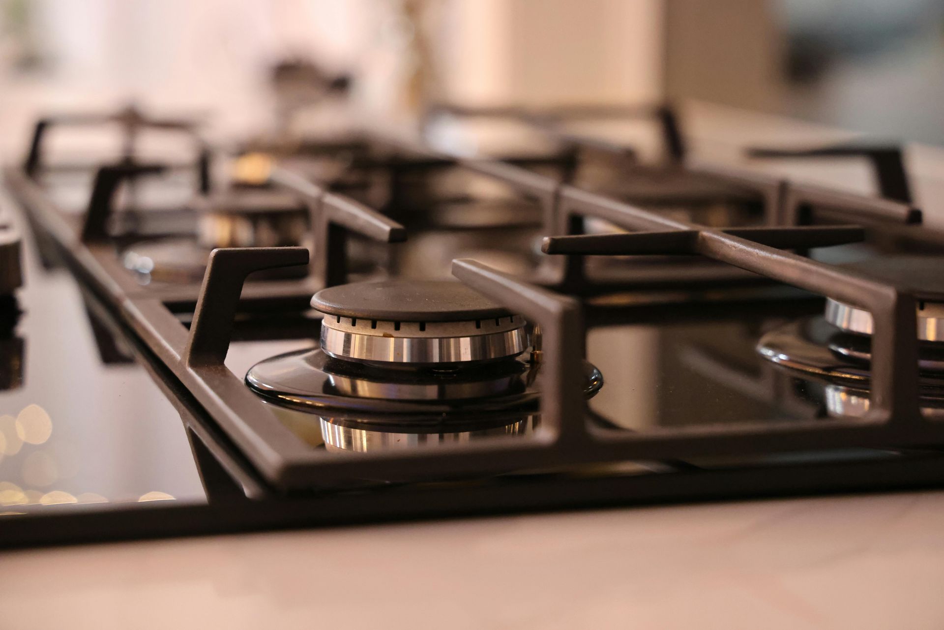 Close-up of a black gas stovetop with burners and metal grates in a kitchen