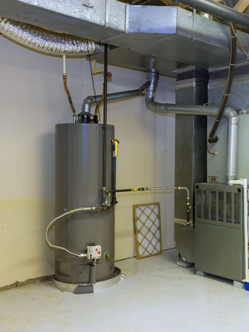 Utility room with a large gray water heater, metal ductwork, and heating equipment on a concrete floor