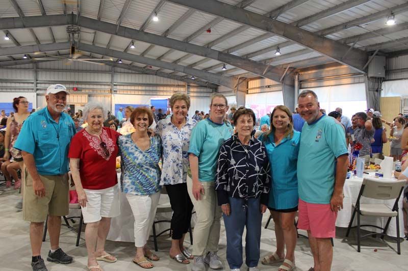 A group of people are posing for a picture in a large room.