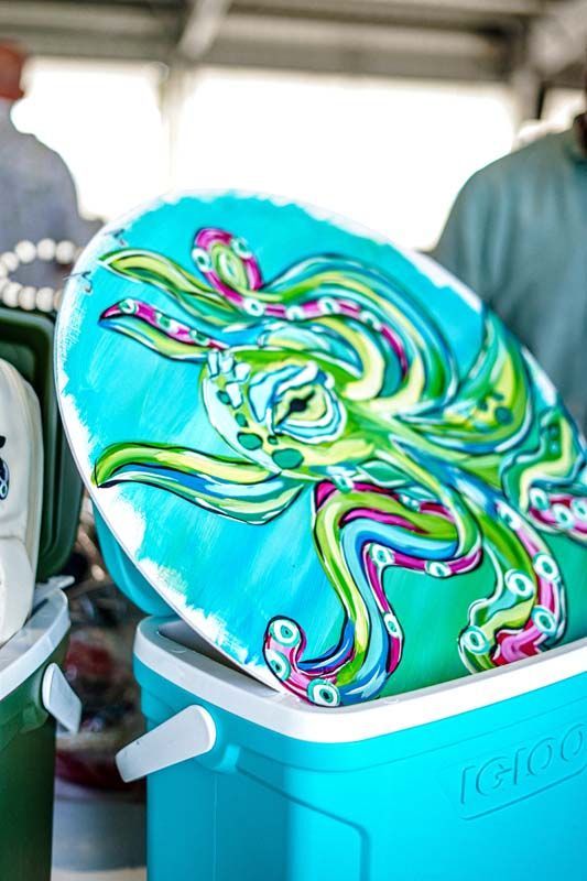 Turquoise cooler holding a colorful swirled round cake or dessert indoors