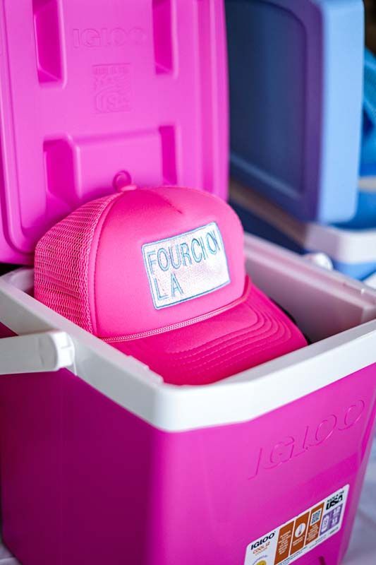 Pink Mini-MA helmet stored in a white bin, with colorful suitcases in the background