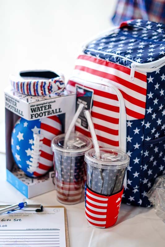 Patriotic football-themed party display with American flag decor, striped cups, and a clear serving container
