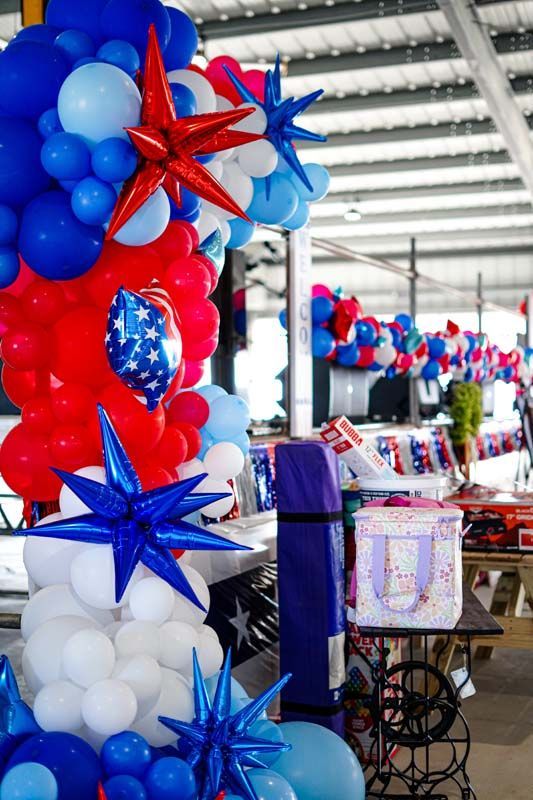 Red, white, and blue balloon decorations at an indoor patriotic event setup