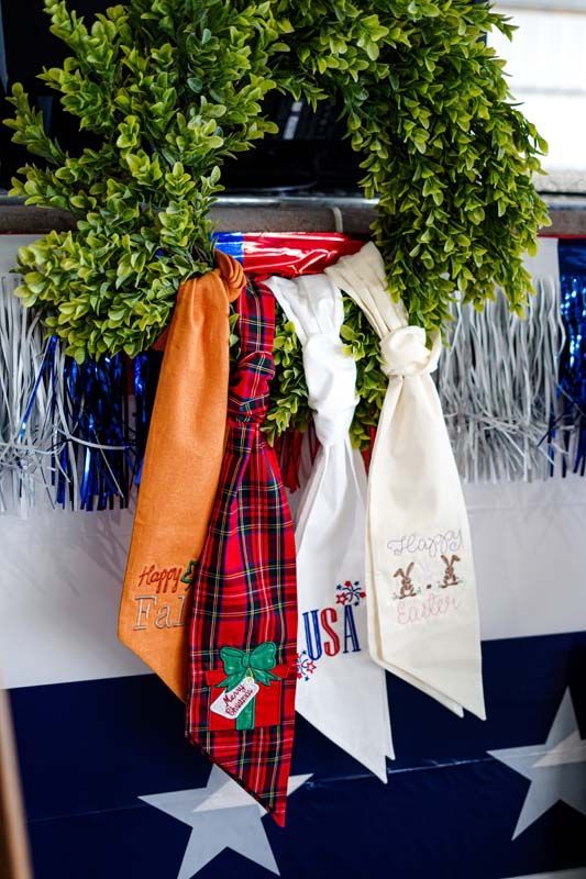 Holiday wreath with hanging red, orange, and white scarves on a festive display