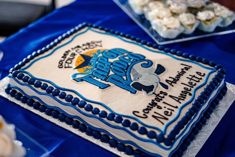 Blue-and-white decorated cake with a cartoon image and “Nei University” text on a table