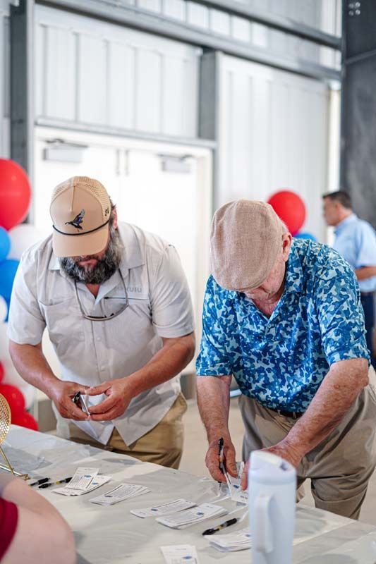 People working at a table sorting papers in an indoor event hall