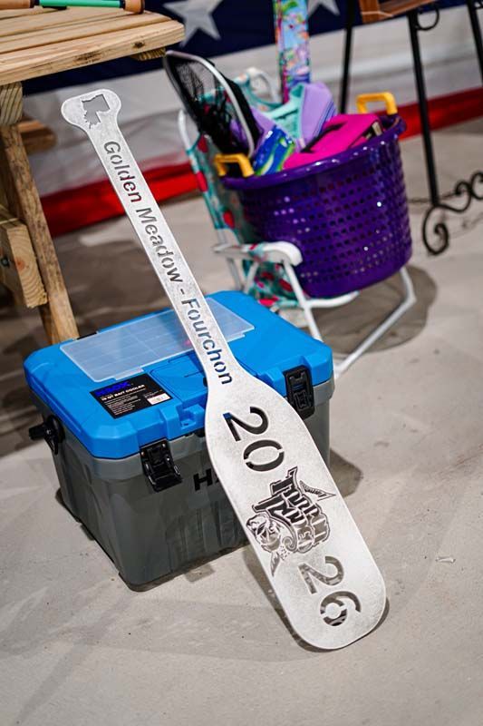 White 2026 ribbon draped over blue and gray equipment next to a purple basket indoors