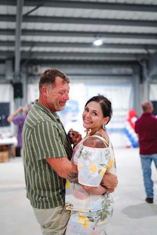 Couple embracing and smiling in a warehouse-like indoor space