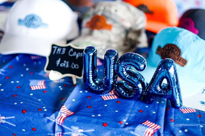 Blue USA balloon centerpiece with patriotic hats and American flag tablecloth