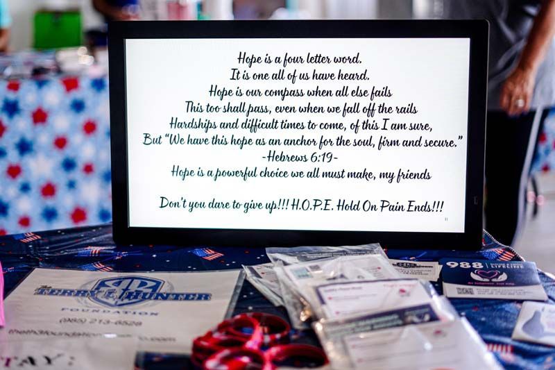 White sign with poem above gift bags and wrapped items on a decorated table