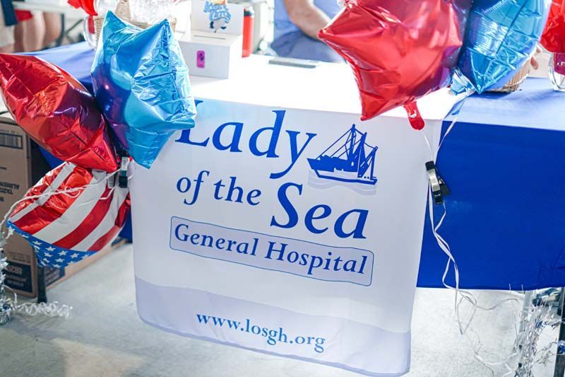 Balloon-decorated Lady of the Sea General Hospital sign with blue and red foil balloons