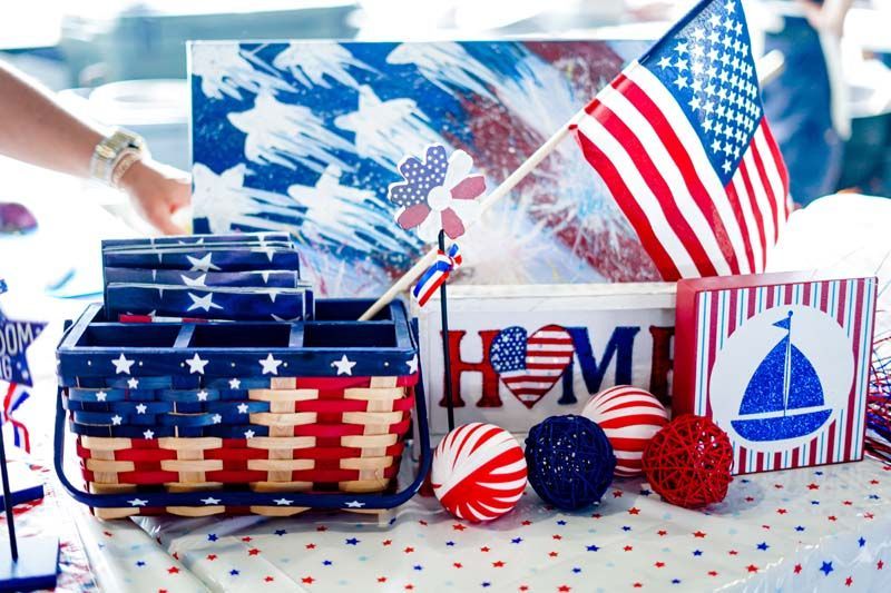 Patriotic red, white, and blue Fourth of July decorations with American flags and festive gift boxes