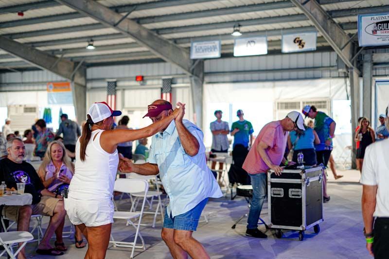 A group of people are dancing in a large room.