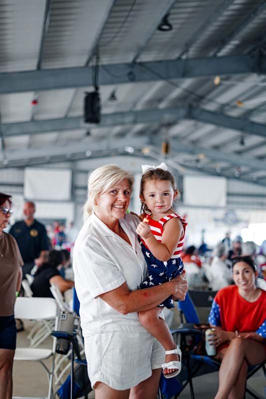 Woman holding a toddler in a bright indoor event space