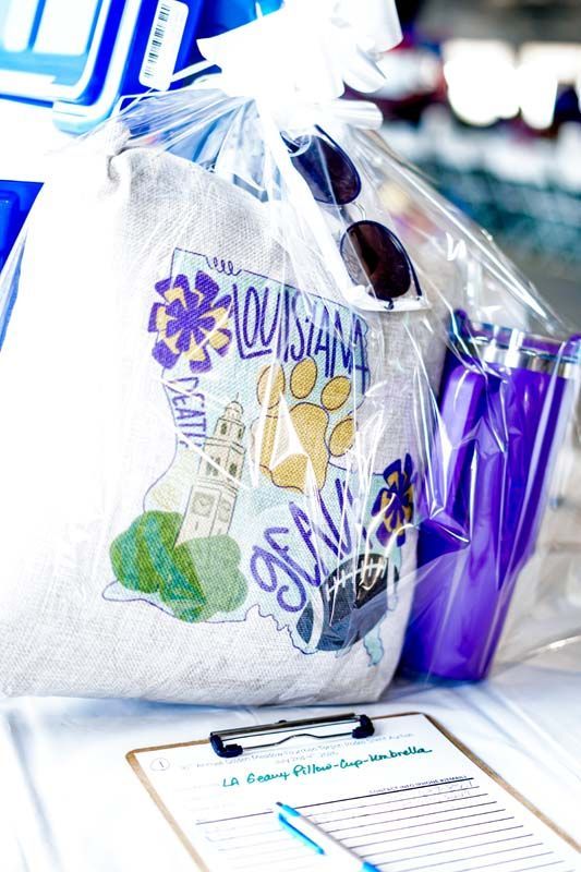 Gift bag with purple mug and notebook on a table, decorated for a celebration