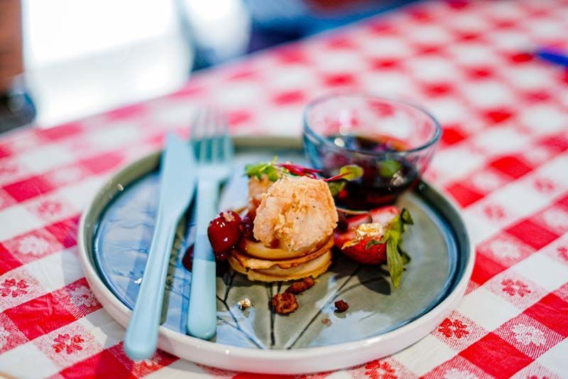 Dessert plate with a scoop of ice cream on a red-and-white checkered tablecloth