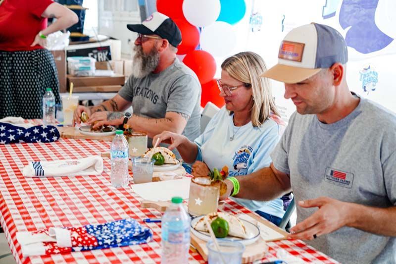 People eating at a checkered table during a casual indoor gathering