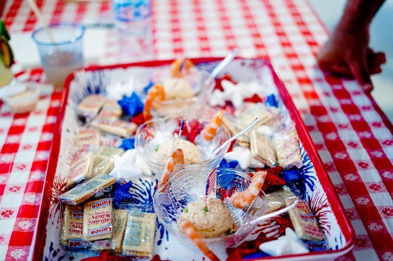 Wrapped food items in clear plastic on a red-and-white checkered tablecloth