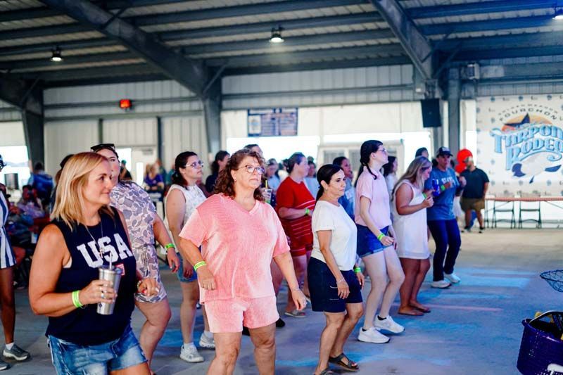 People dancing in a hall, lined up side by side during a group dance session