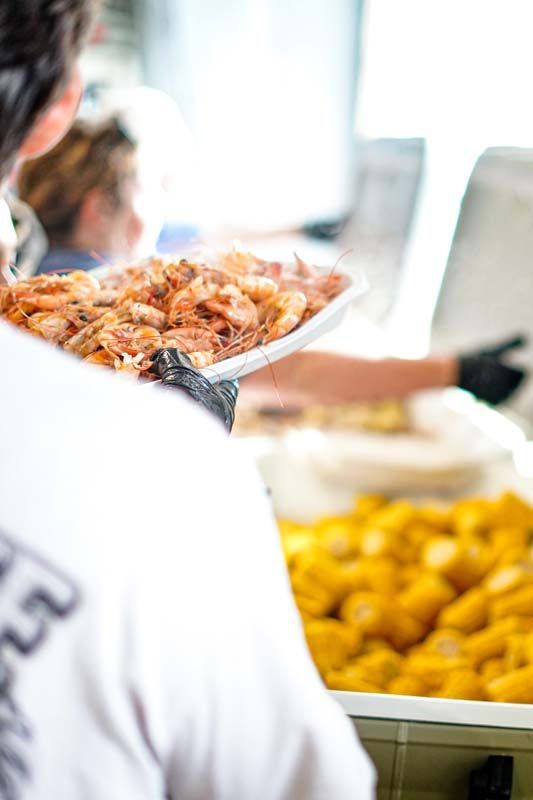 A person is holding a plate of shrimp over their shoulder.