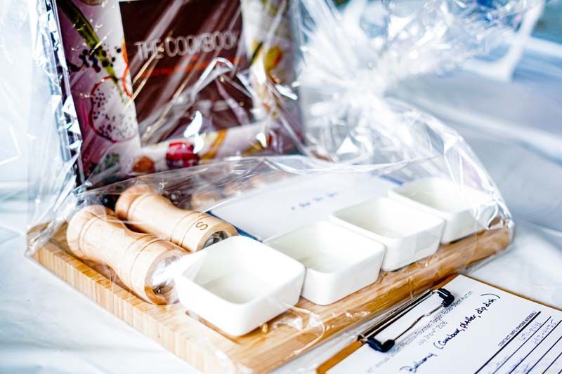 Small kitchen countertop with packaged food, bread, and white square containers arranged on a cutting board.