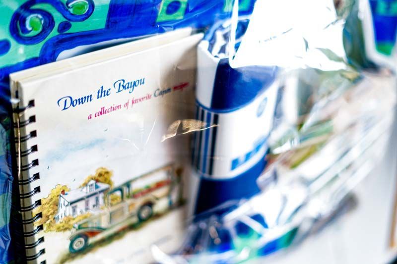 Books and glassware on a shelf, with a blue-and-white ceramic mug in the foreground