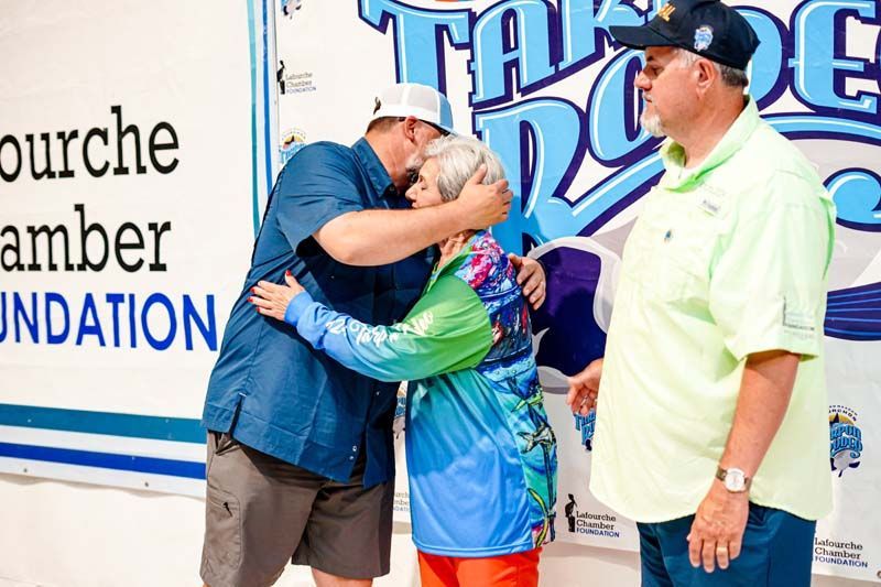 A man is hugging a woman in front of a sign that says amber foundation.