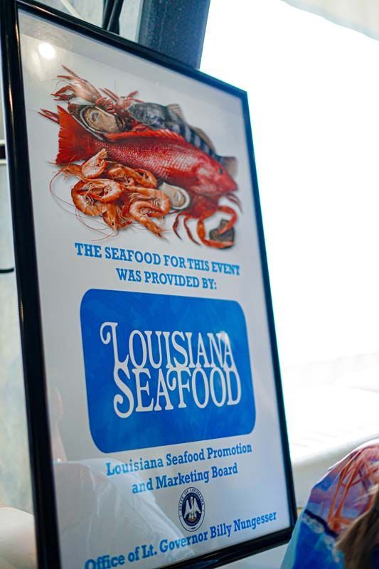 Louisiana Seafood poster with red crab and fish illustration on a blue-and-white sign