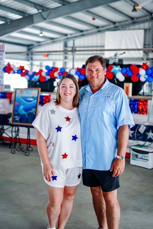 Two people standing together at a festive event with red, white, and blue decorations