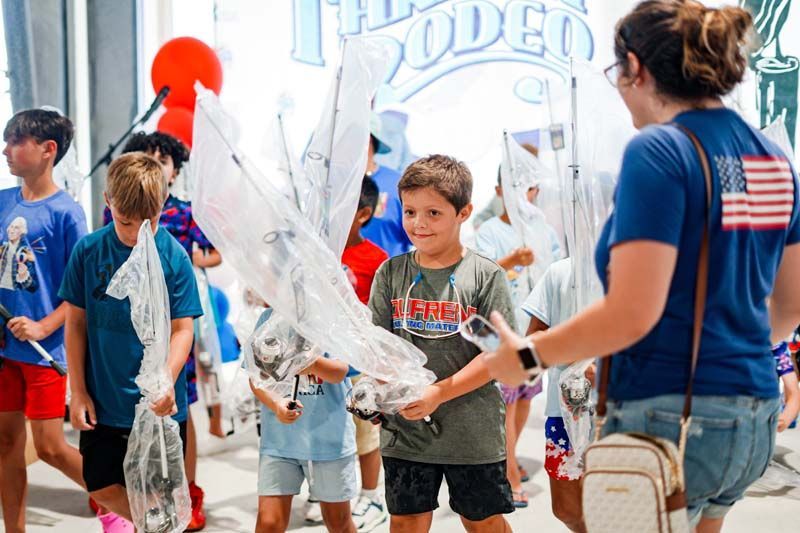 Children outdoors playing with large translucent balloons at a lively event with colorful decorations