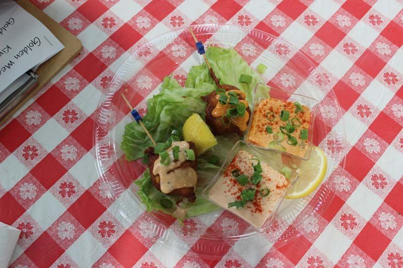 A plate of food on a checkered tablecloth on a table.