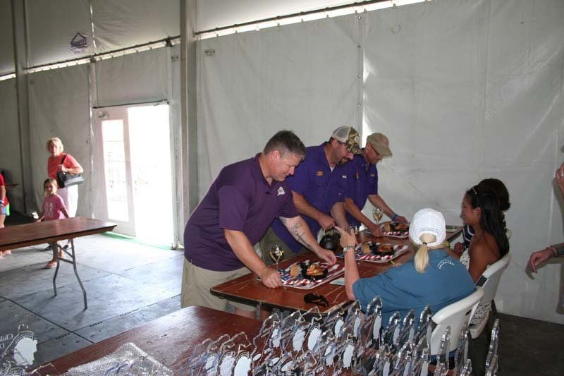 A group of people are gathered around a table in a tent