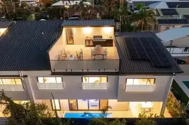 House with rooftop solar panels and pool