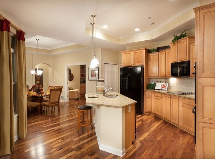 Two people assembling kitchen cabinets in a partly renovated kitchen, one standing on a step stool.