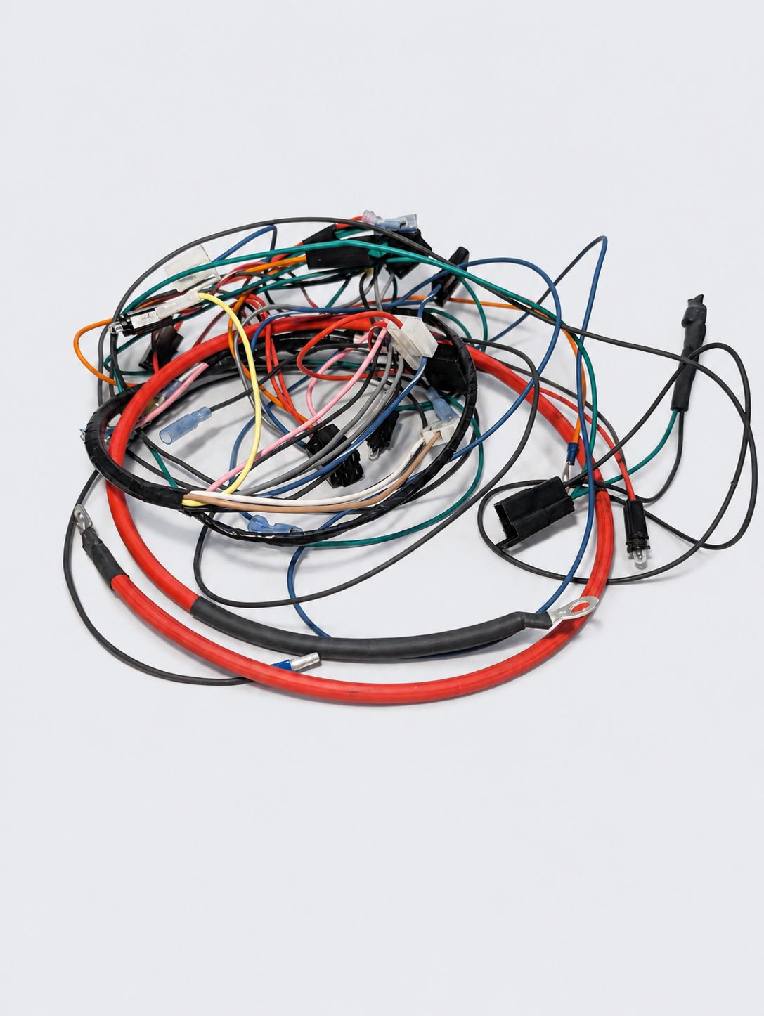 Coiled bundle of assorted multicolored cables and wires on a white surface
