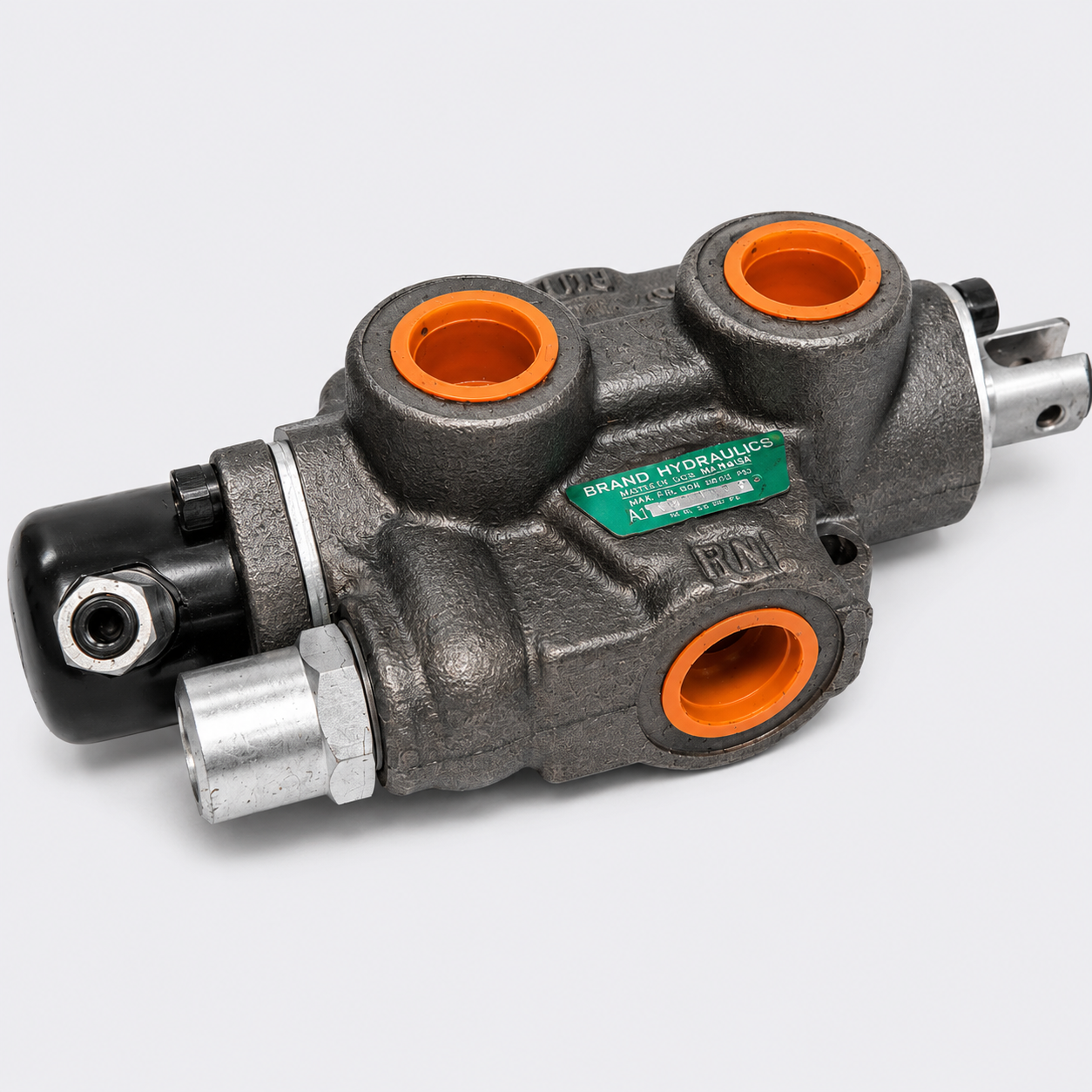 Industrial hydraulic valve block with orange ports and black fittings on a white background