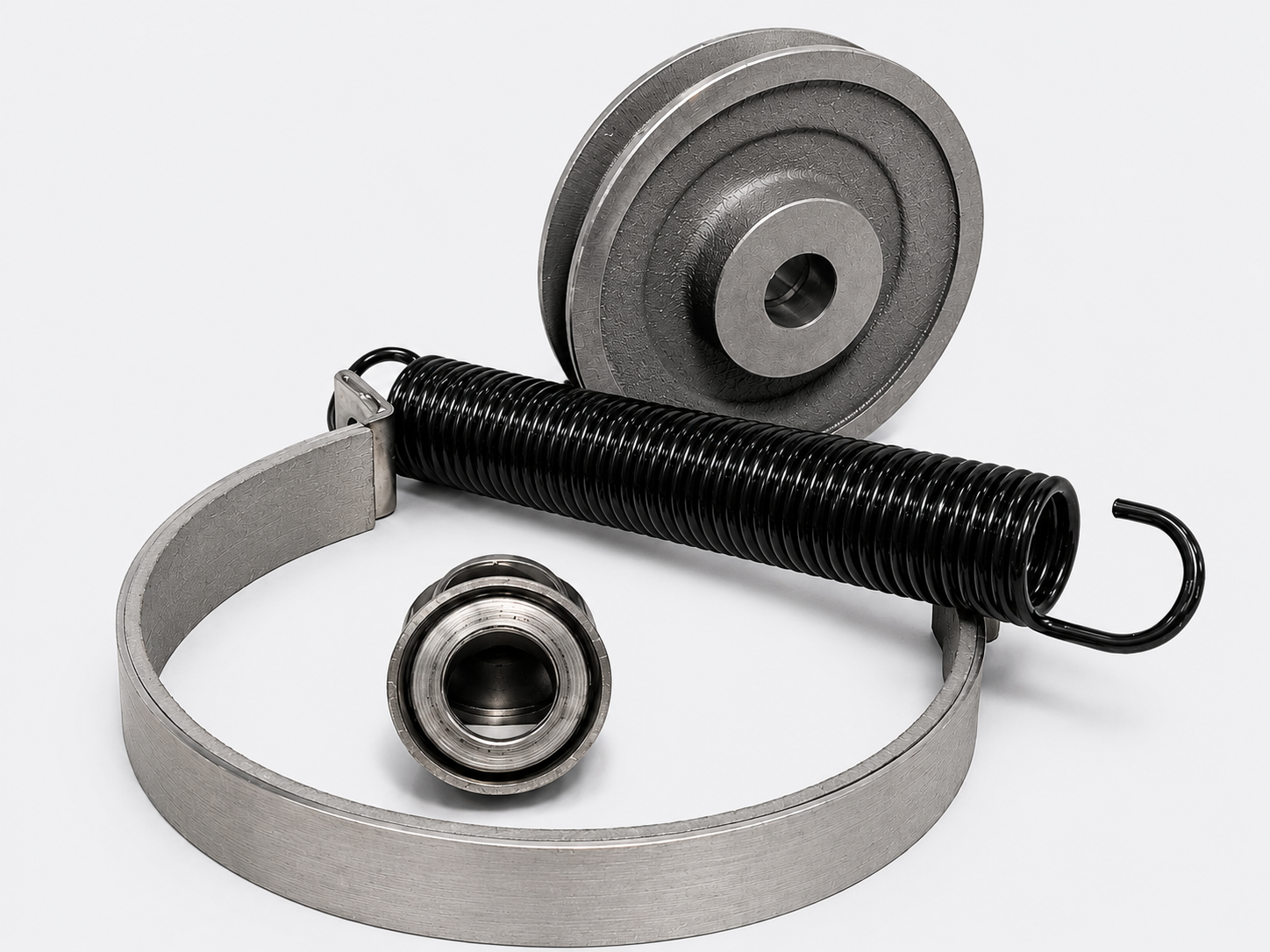 Metal spring-loaded pulley assembly with gray strap, black spring, and small bearing on white background