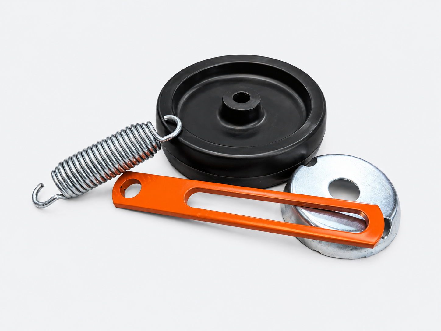 Black and silver pulley assembly with orange strap and coiled spring on white background