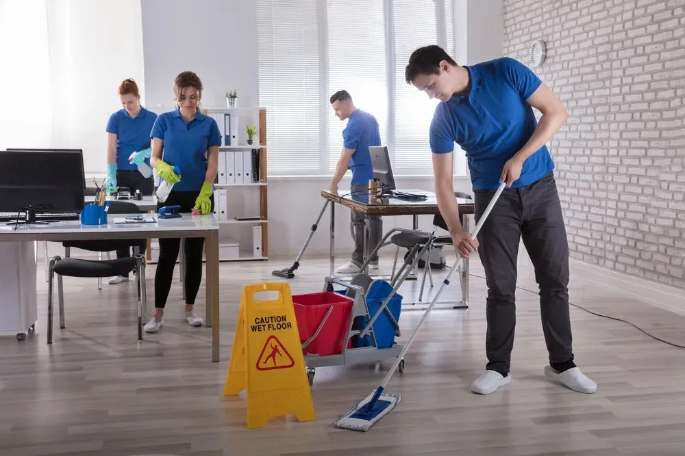 Office Cleaners in Blue Shirts Clean an Office — Jamac Cleaning Services in Belmont, NSW