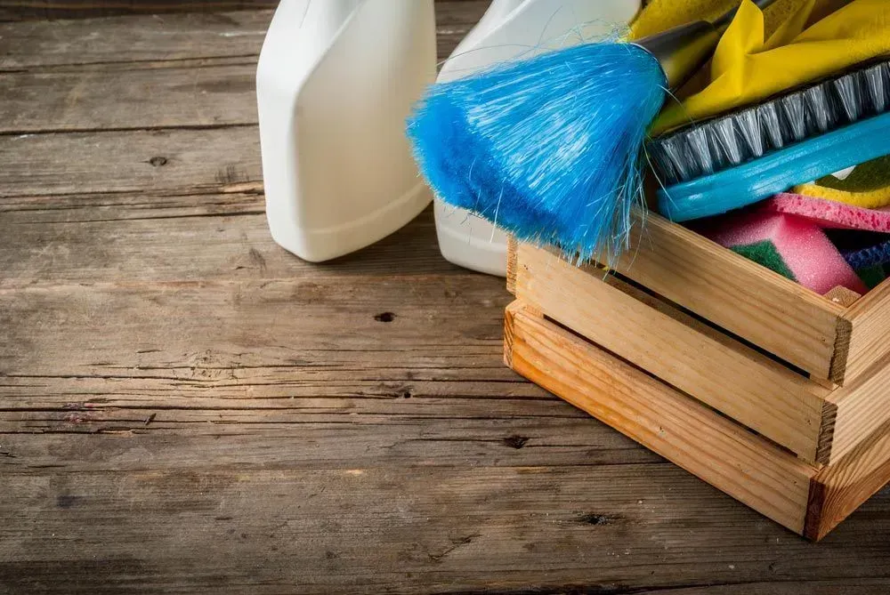 Cleaning Supplies in a Wooden Crate on a Wooden Surface — Jamac Cleaning Services in Newcastle, NSW