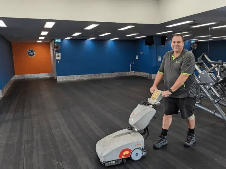 Man Cleaning Gym Floor With Machine — Jamac Cleaning Services in Belmont, NSW