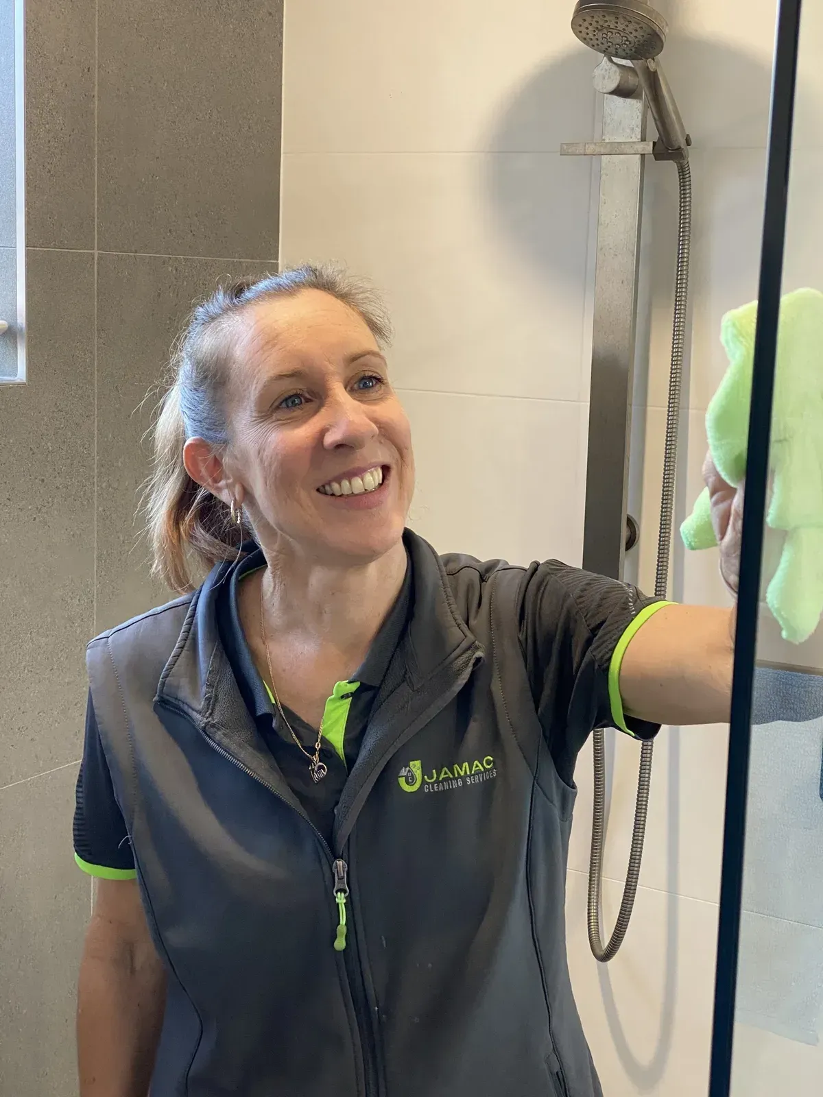 Woman Cleaning a Shower — Jamac Cleaning Services in Mayfield, NSW