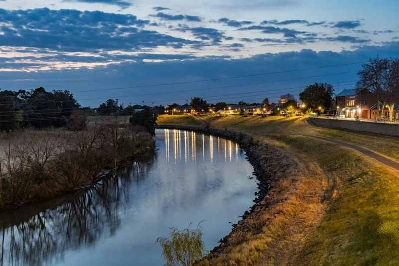Curving River at Dusk With Streetlights — Jamac Cleaning Services in Maitland, NSW