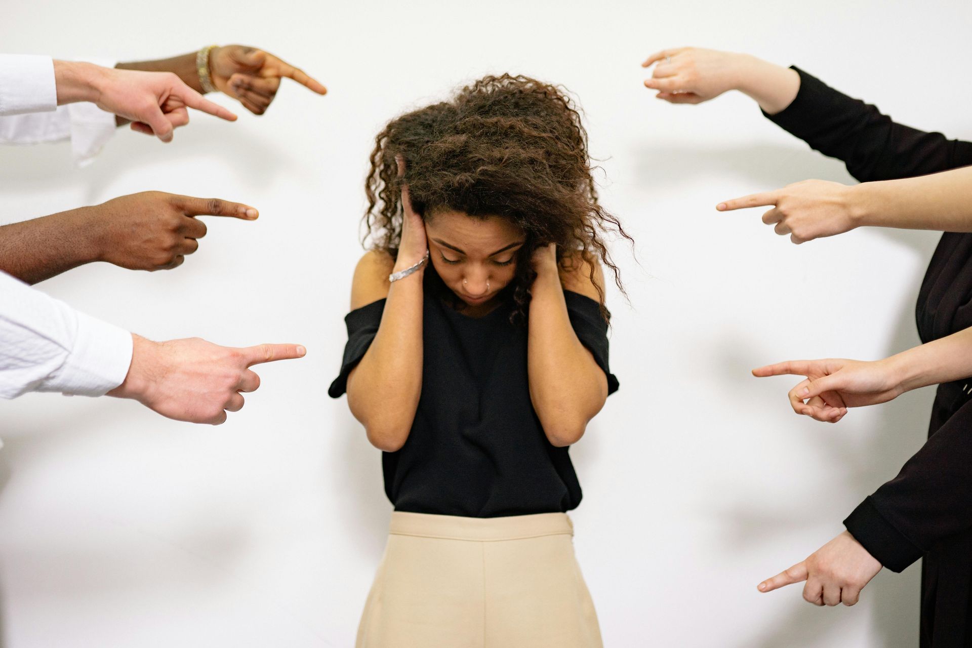 Woman coveing ears to tune out inner and outer critics
