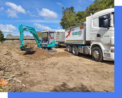 A white truck and a green excavator are parked in a dirt field.