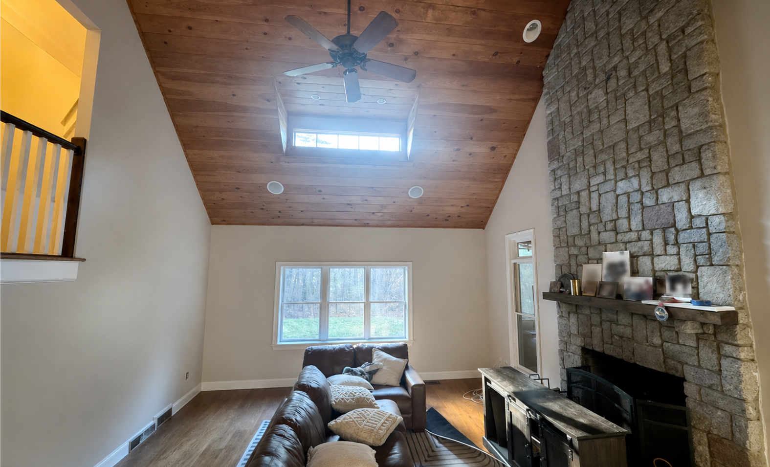 Professionally painted living room with high wood ceiling and stone fireplace in Norton, MA